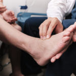 foot and ankle doctor taking patient's pulse in the foot